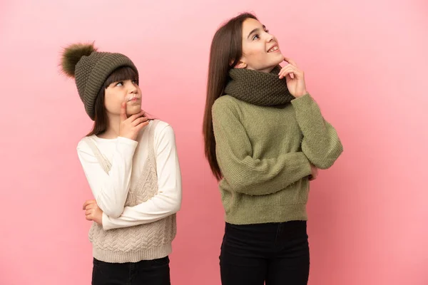 Irmãzinhas Vestindo Uma Roupa Inverno Isolada Fundo Rosa Pensando Uma — Fotografia de Stock