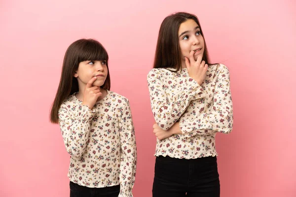 Irmãzinhas Meninas Isoladas Fundo Rosa Com Dúvidas Olhar Para Cima — Fotografia de Stock