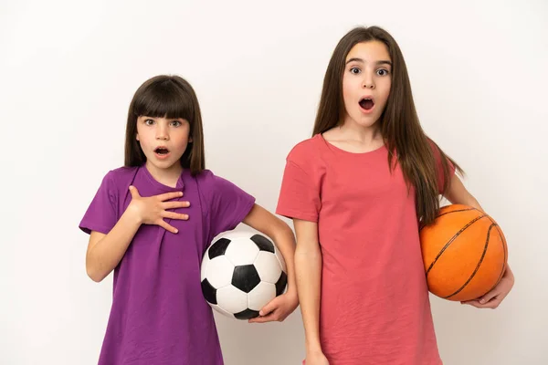 축구와 농구를 자매들이 놀랍고 충격적 표정으로 배경에서 고립되어 — 스톡 사진