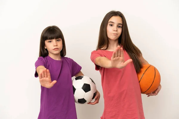 축구와 농구를 자매들은 배경에 고립되어 몸짓을 멈추고 생각하고 상황을 부인한다 — 스톡 사진