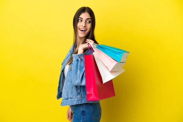 Ung Kaukasisk Kvinna Isolerad Blå Bakgrund Håller Shoppingväskor Och Ser — Stockfoto