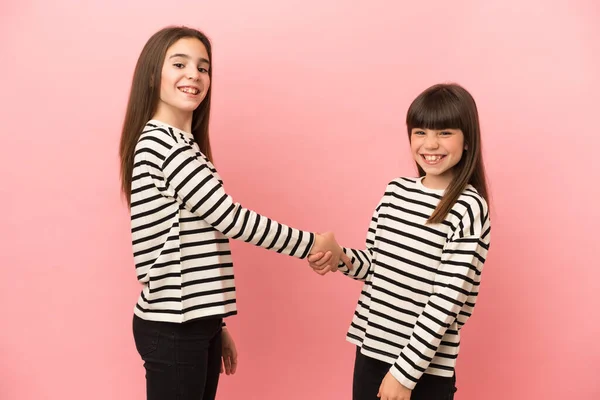 Irmãzinhas Meninas Isoladas Fundo Rosa Handshaking Depois Bom Negócio — Fotografia de Stock