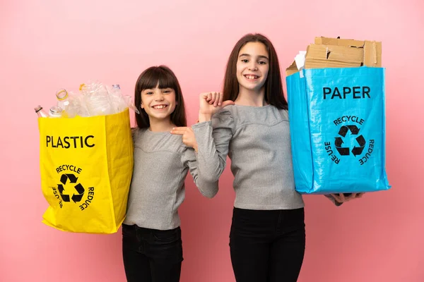 Küçük Kız Kardeşler Geri Dönüşüm Kağıtlarını Plastikleri Pembe Arka Planda — Stok fotoğraf