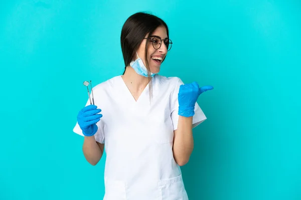 Junge Kaukasische Zahnärztin Mit Werkzeugen Auf Blauem Hintergrund Die Zur — Stockfoto