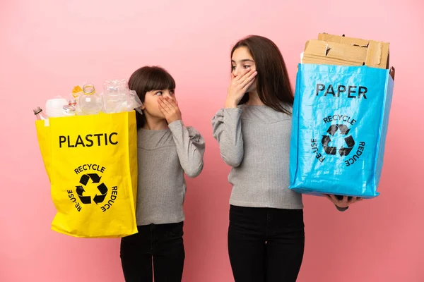 Irmãzinhas Reciclando Papel Plástico Isolado Fundo Rosa Cobrindo Boca Com — Fotografia de Stock