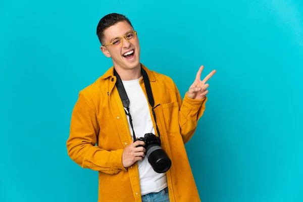 Young Caucasian Photographer Man Isolated Blue Background Smiling Showing Victory — Stock Photo, Image