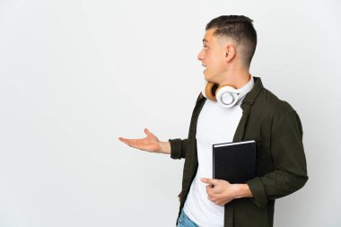 Beyaz arka planda beyaz tenli genç bir öğrencinin sürpriz bir ifadeyle yan yana bakması...