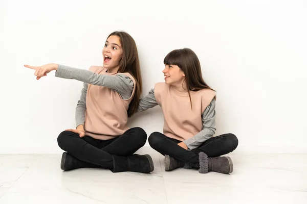 Маленькі Сестри Сидять Підлозі Ізольовані Білому Тлі Представляючи Ідею Дивлячись — стокове фото