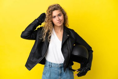 Motosiklet kasklı genç sarışın kadın sarı arka planda izole edilmiş şüpheleri var.