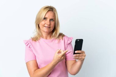 Beyaz arka planda izole edilmiş ve işaret edilen cep telefonu kullanan orta yaş