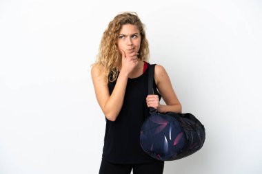 Spor çantalı genç kadın beyaz arka planda izole edilmiş şüpheleri ve düşünceleri var.