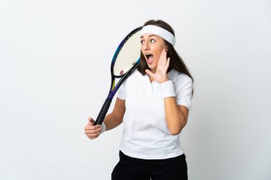 İzole edilmiş beyaz arka planda genç bayan tenisçi ağzı sonuna kadar açık bağırıyor.