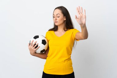 Genç futbolcu kadın izole edilmiş beyaz arka planda durma hareketi yapıyor ve hayal kırıklığına uğruyor.
