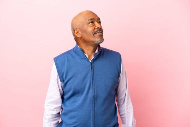 Kübalı son sınıf öğrencisi pembe arka planda izole edilmiş ve araştırılıyor