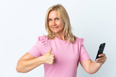 Beyaz arka planda izole edilmiş cep telefonu kullanan orta yaş. Başparmaklar yukarı çünkü iyi bir şey oldu.