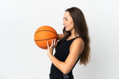 İzole edilmiş beyaz arka planda basketbol oynayan genç İspanyol kadın.