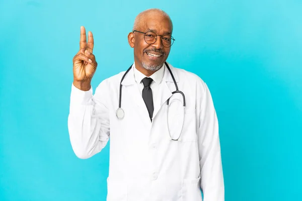 Senior Medico Uomo Isolato Sfondo Blu Sorridente Mostrando Segno Vittoria — Foto Stock