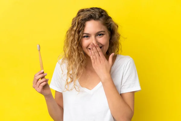 Młoda Biała Kobieta Trzymająca Szczotkujące Zęby Wyizolowane Żółtym Tle Szczęśliwa — Zdjęcie stockowe