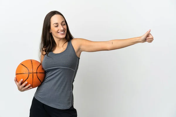 若いです女性遊びバスケットボール上の隔離された白い背景与えますA親指アップジェスチャー — ストック写真