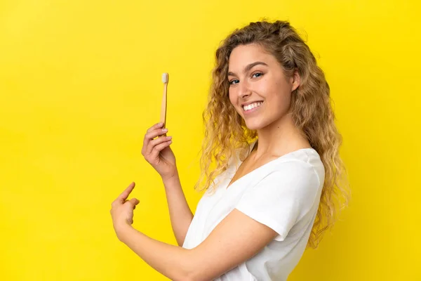 Νεαρή Καυκάσια Γυναίκα Που Κρατάει Ένα Βουρτσισμένο Δόντι Απομονωμένο Κίτρινο — Φωτογραφία Αρχείου