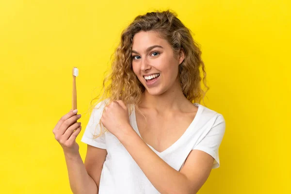 Νεαρή Καυκάσια Γυναίκα Που Κρατάει Ένα Βουρτσισμένο Δόντι Απομονωμένο Κίτρινο — Φωτογραφία Αρχείου