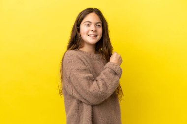 Sarı arka planda izole edilmiş küçük beyaz kız zaferi kutluyor.