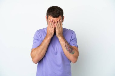 Genç Brezilyalı adam beyaz arka planda izole edilmiş, yorgun ve hasta bir ifadeyle.