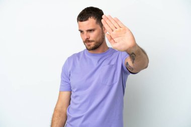 Beyaz arka planda izole edilmiş genç Brezilyalı adam dur hareketi yapıyor ve hayal kırıklığına uğruyor.