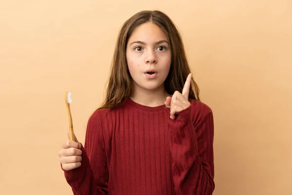 Menina Caucasiana Escovar Dentes Isolados Fundo Bege Pensando Uma Ideia — Fotografia de Stock