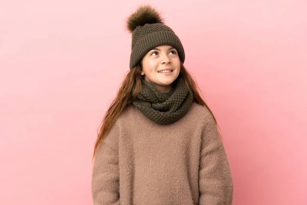 Κοριτσάκι Χειμωνιάτικο Καπέλο Απομονωμένο Ροζ Φόντο Σκέφτεται Μια Ιδέα Ενώ — Φωτογραφία Αρχείου