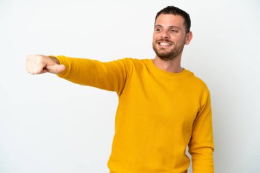 Beyaz arka planda izole edilmiş genç Brezilyalı bir adam baş parmak hareketi yapıyor.