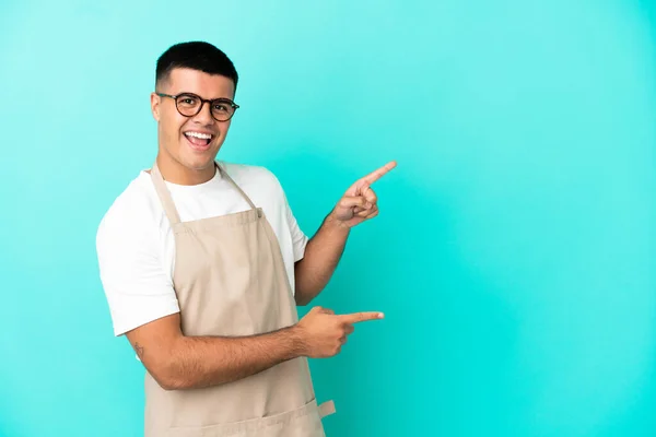 Restauracja Kelner Człowiek Nad Odizolowanym Niebieskim Tle Wskazując Palcem Bok — Zdjęcie stockowe
