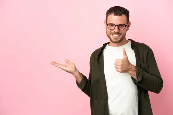 Jovem Brasileiro Isolado Fundo Rosa Segurando Copyspace Imaginário Palma Mão — Fotografia de Stock