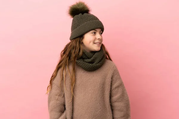 Liten Flicka Med Vinter Hatt Isolerad Rosa Bakgrund Tittar Sidan — Stockfoto