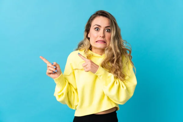 Mujer Brasileña Joven Aislada Sobre Fondo Azul Asustada Señalando Lado — Foto de Stock