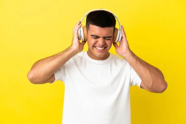 Νέος Όμορφος Άντρας Πάνω Από Απομονωμένο Κίτρινο Φόντο Ακούγοντας Μουσική — Φωτογραφία Αρχείου