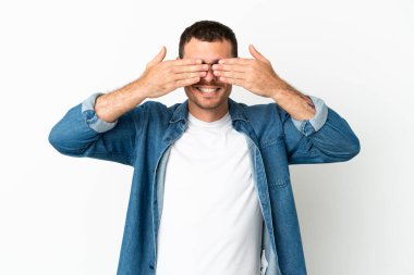 İzole edilmiş beyaz arka plan üzerinde Brezilyalı bir adam. Gözleri elleriyle kaplıyor ve gülümsüyor.