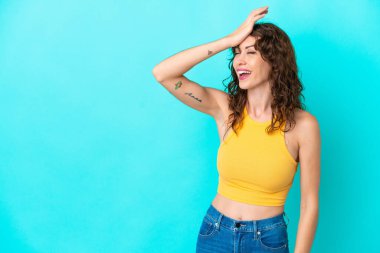 Mavi arka planda izole edilmiş kıvırcık saçlı genç kadın bir şeyin farkına vardı ve çözüme niyetlendi.