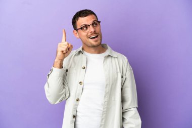 Mor arka planda kalan Brezilyalı bir adam parmağını kaldırırken çözümü bulmayı amaçlıyor.