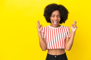 Sarı arka planda izole edilmiş genç Afrikalı Amerikalı kadın.