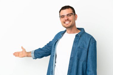 İzole edilmiş beyaz arka plan üzerinde Brezilyalı bir adam. Davet etmek için ellerini yana uzatıyor.