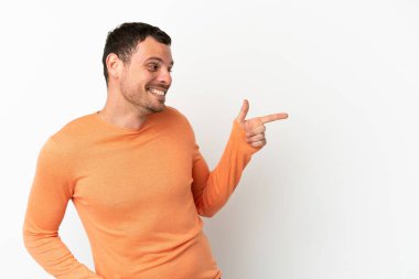 İzole edilmiş beyaz arkaplan üzerinde Brezilyalı bir adam parmak işareti yapıyor ve bir ürün sunuyor