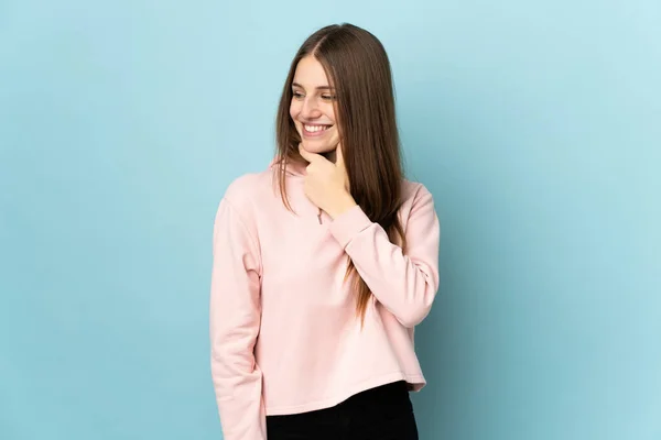 Jonge Blanke Vrouw Geïsoleerd Blauwe Achtergrond Kijken Naar Zijkant Glimlachen — Stockfoto