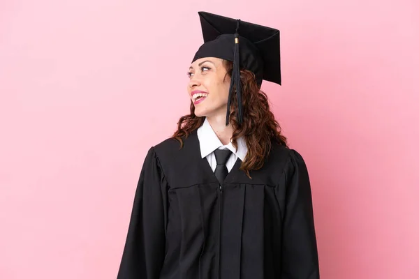 Giovane Laureata Donna Isolato Sfondo Rosa Cercando Lato — Foto Stock