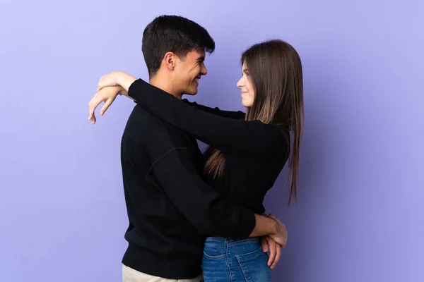 离群索居的紫色背景的年轻夫妇拥抱 — 图库照片