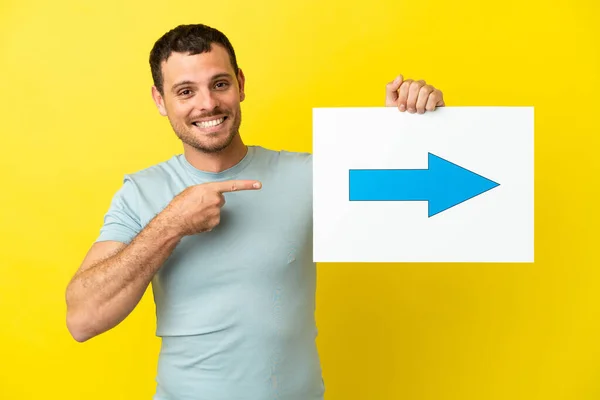 Braziliaanse Man Geïsoleerde Paarse Achtergrond Met Een Bordje Met Pijl — Stockfoto