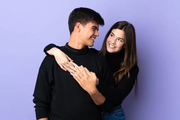 Casal Jovem Sobre Isolado Fundo Roxo Rindo Abraçando — Fotografia de Stock