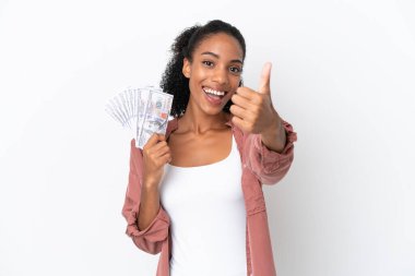 Genç Afrikalı Amerikalı bir kadın beyaz arka planda izole edilmiş bir sürü para alıyor. Başparmakları havada çünkü iyi bir şey oldu.