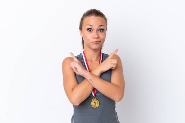 Beyaz arka planda madalyaları olan genç Rus spor kızı, yan kesimlerin kuşkuları olduğunu gösteriyor.