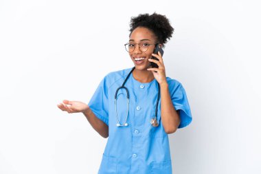 Genç cerrah Afrikalı Amerikalı doktor kadın beyaz arka planda izole edilmiş cep telefonuyla biriyle sohbet ediyor.